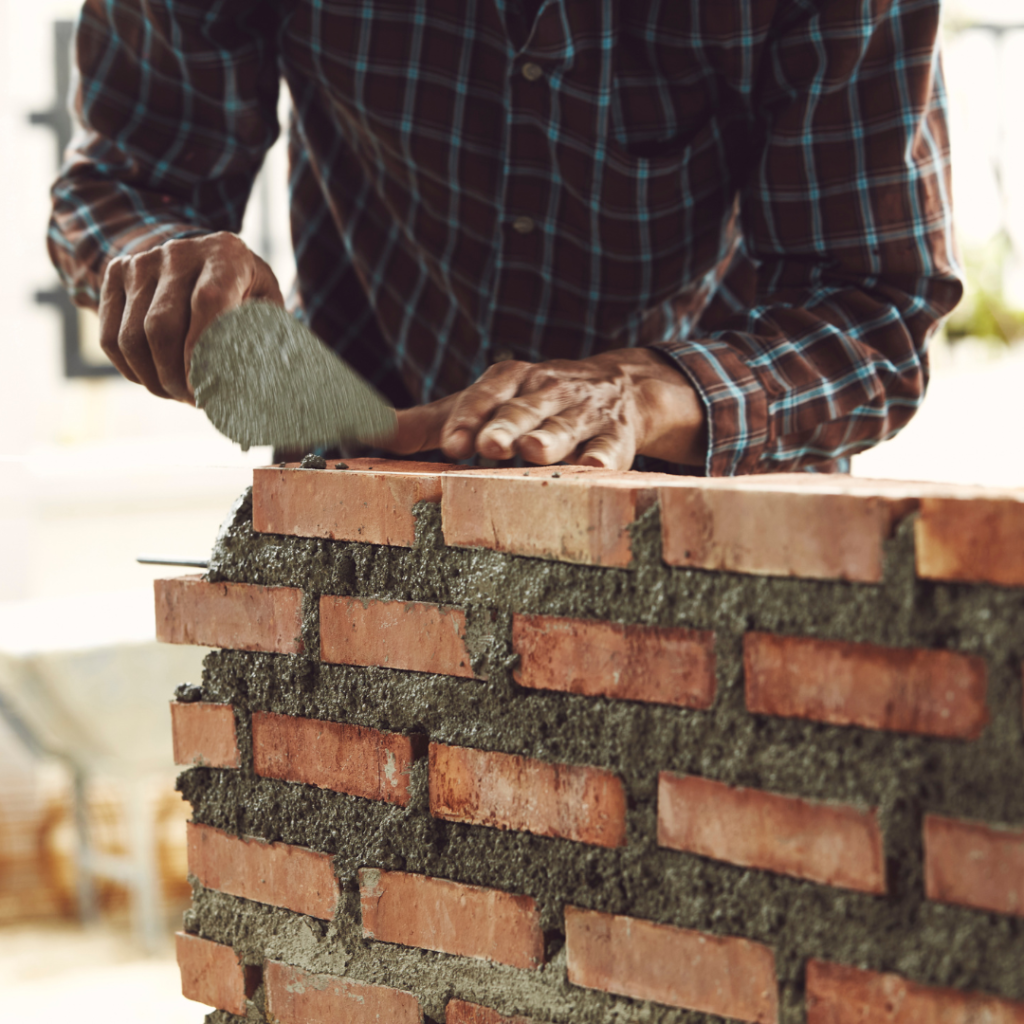Masonry construction work with brick and stone installation on a commercial building in Texas.